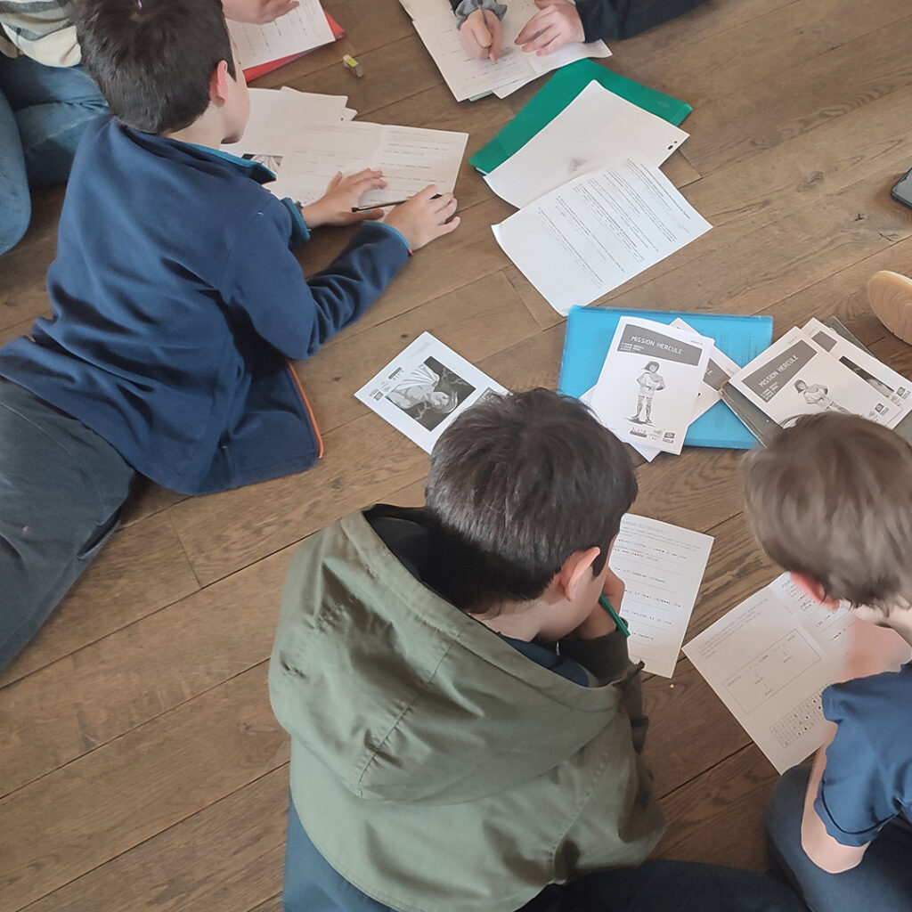 Un groupe d'élèves complète les livrets d'une activité.