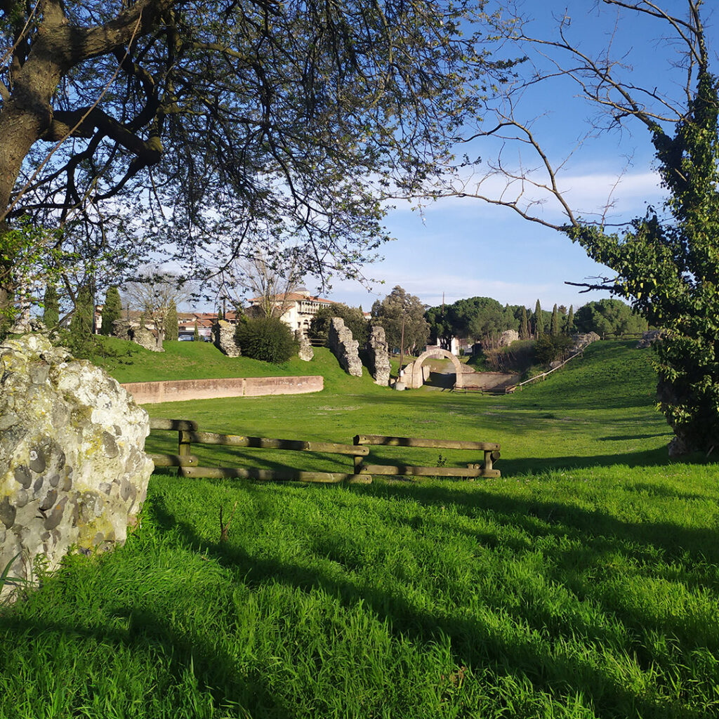 Vue depuis l’intérieur de l’amphithéâtre romain de Purpan-Ancely : on peut voir l'arène, les vestiges d'un vomitoire, la reconstitution de l'une des entrées et du mur séparant l'arène des gradins.